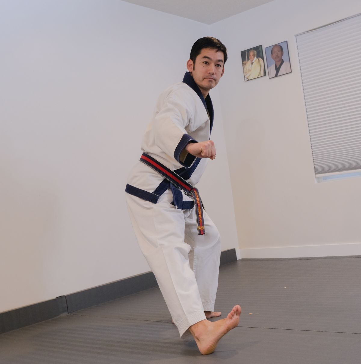 Brian Corrales, Sa Bom, stepping into a forward stance reverse punch in the Wasatch Martial Arts Academy dojang