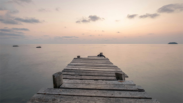 A jetty reaching towards a tranquil sea