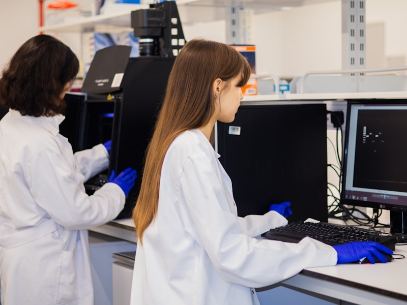 Two scientists working at computer workstations in a lab