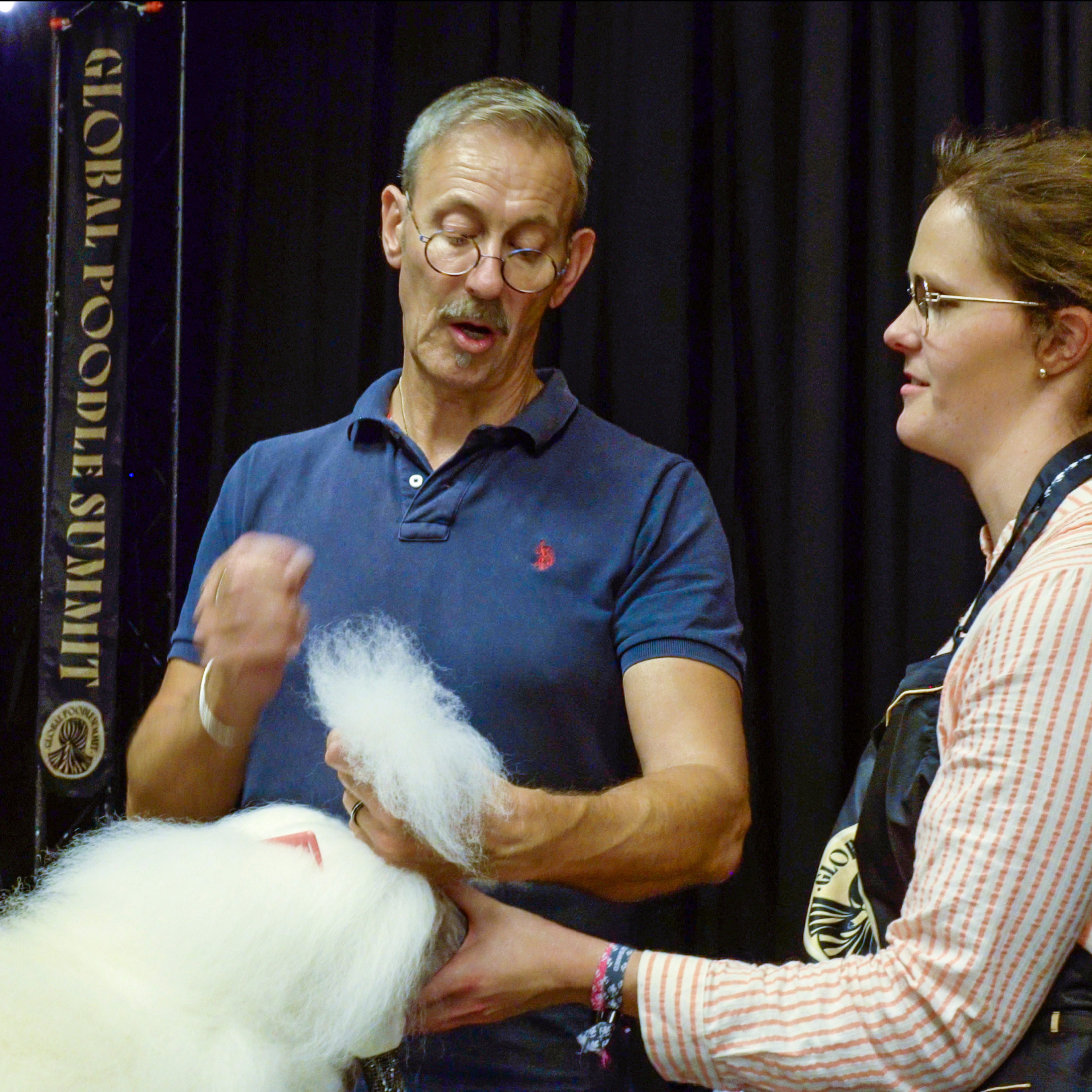 Michael Gadsby spraying up white Poodle with student