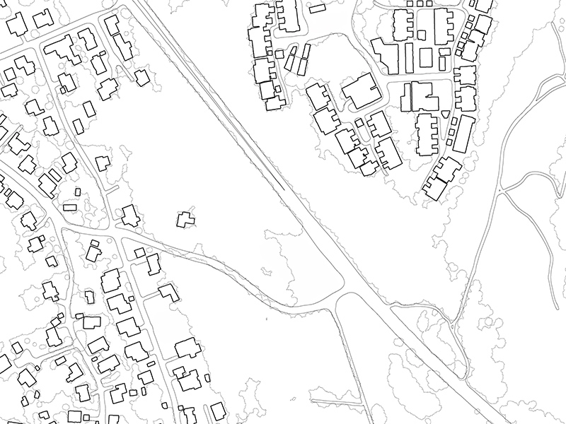 Black-and-white site plan showing building footprints, roads and surrounding forest outlines.