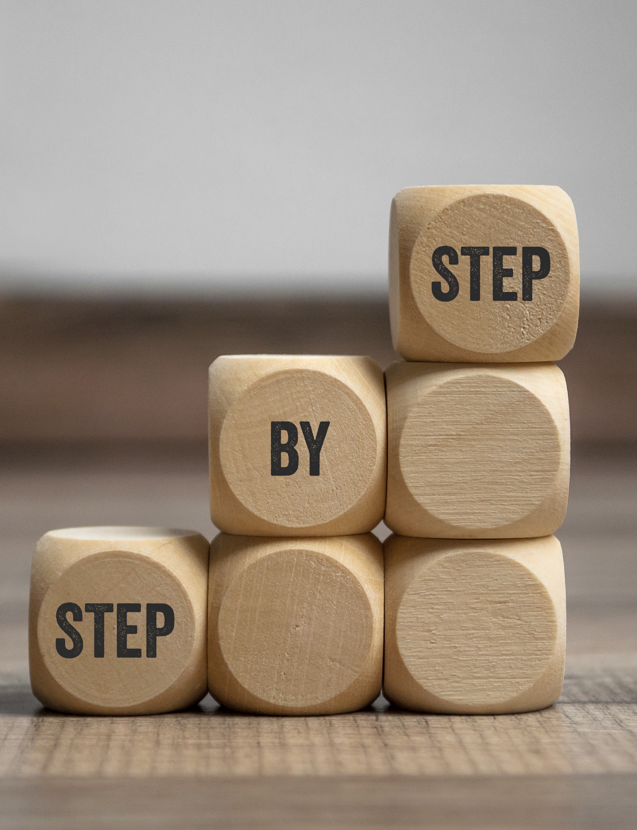 A stack of blocks arranged to look like three steps with the message step by step to suggest the licensing process consists of a number of steps