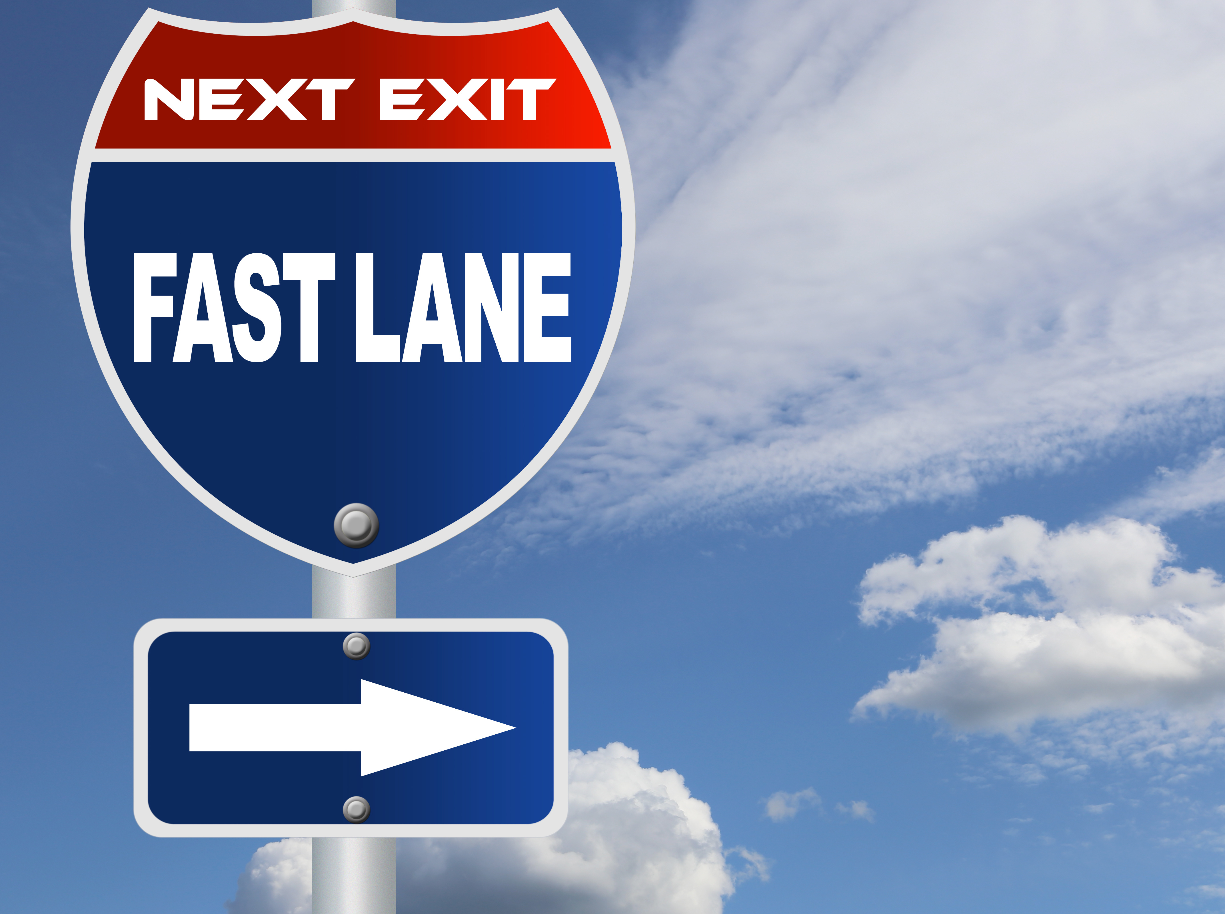 The image is on the left of the box. A sign that looks just like an Interstate Highway sign. It says Next Exit Fast Lane and there is an arrow pointing to the text on the right