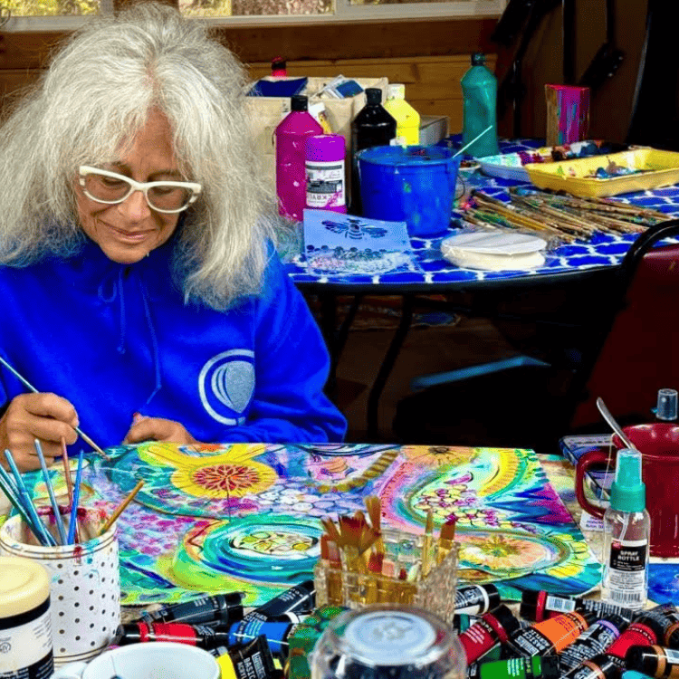 Woman creating a colorful sacred painting during the Joseph retreat.