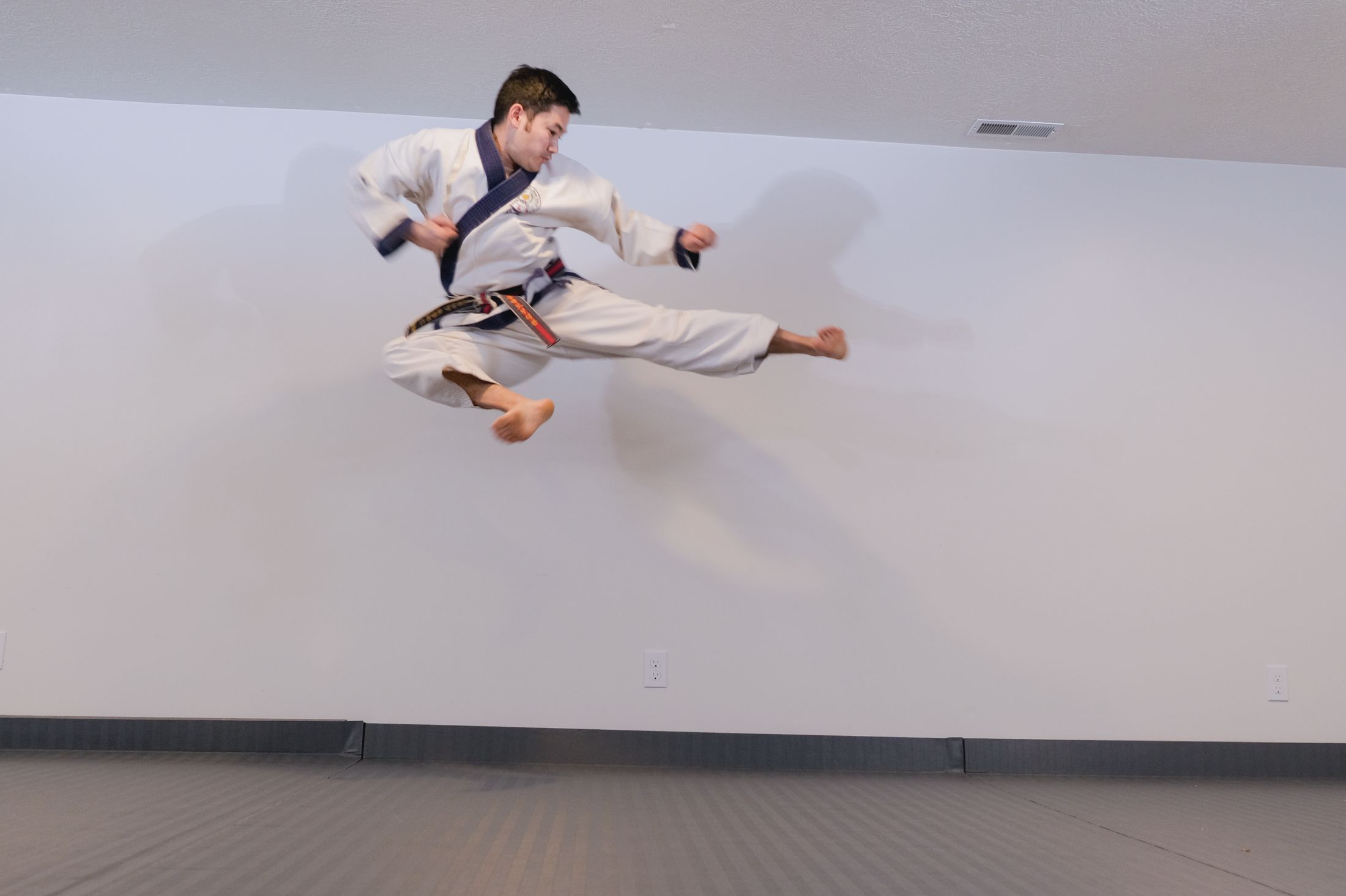 Brian Corrales executing a jumping side kick in the Wasatch Martial Arts Academy dojang