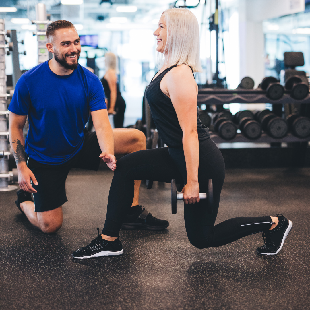 Personal trainer with female client doing a lunge