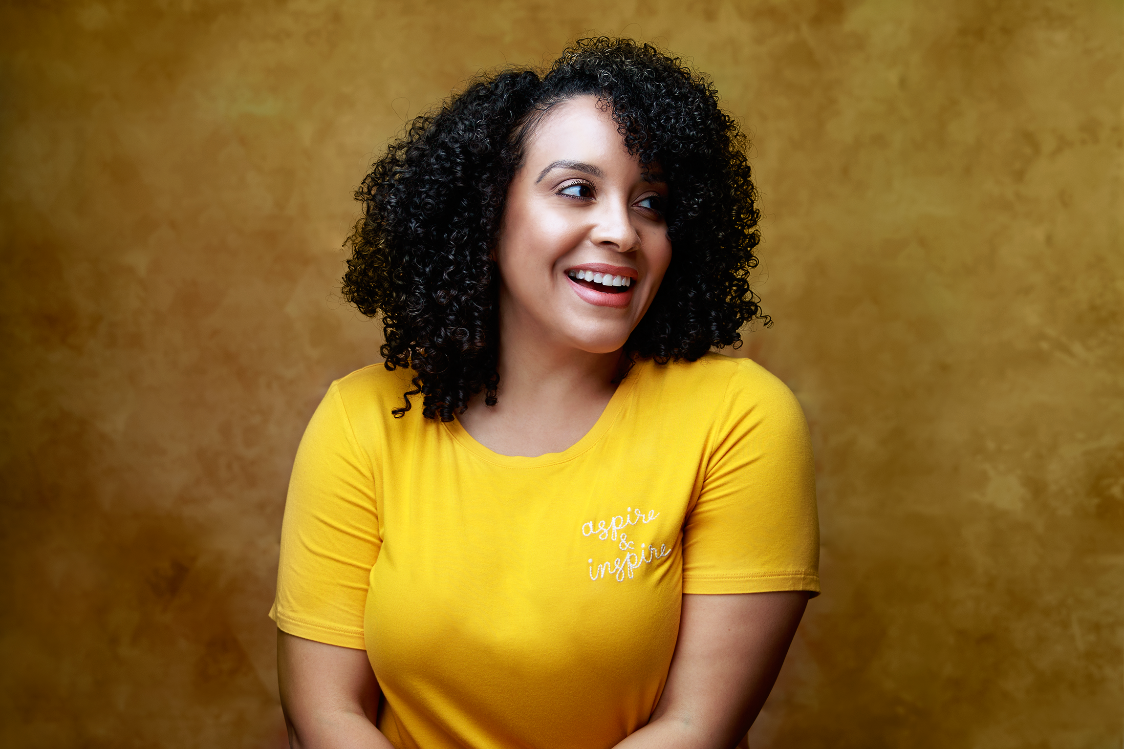 actor Miriam Morales. curly girl, yellow shirt