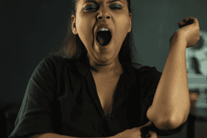 A tired female bedtime procrastinator yawns