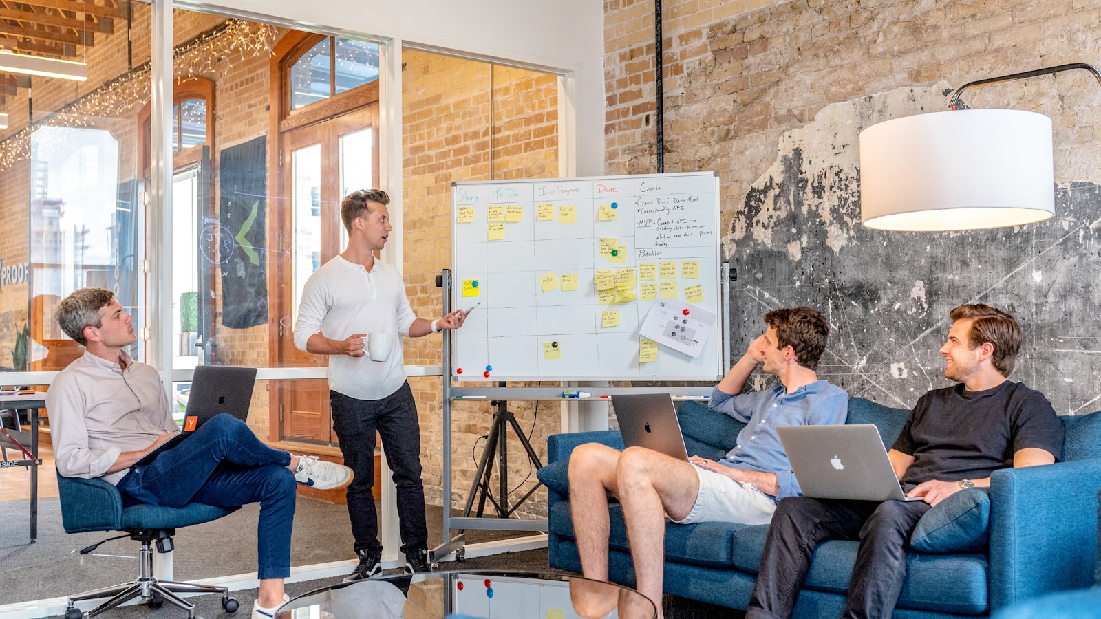 A research team planning at a whiteboard covered in sticky notes