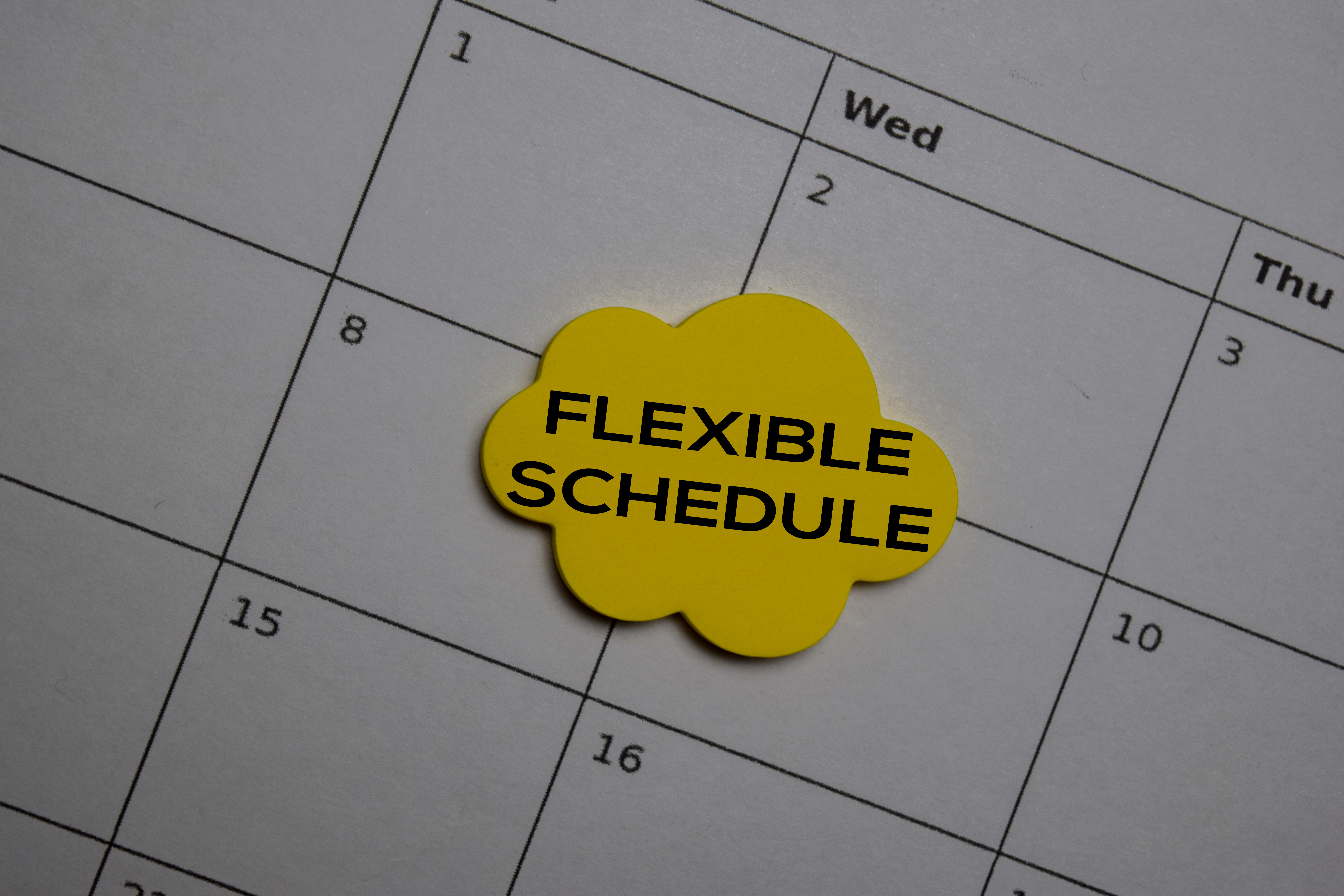 An image of a a page from a large desk blotter calendar. I has a yellow sticky note saying Flexible Schedule