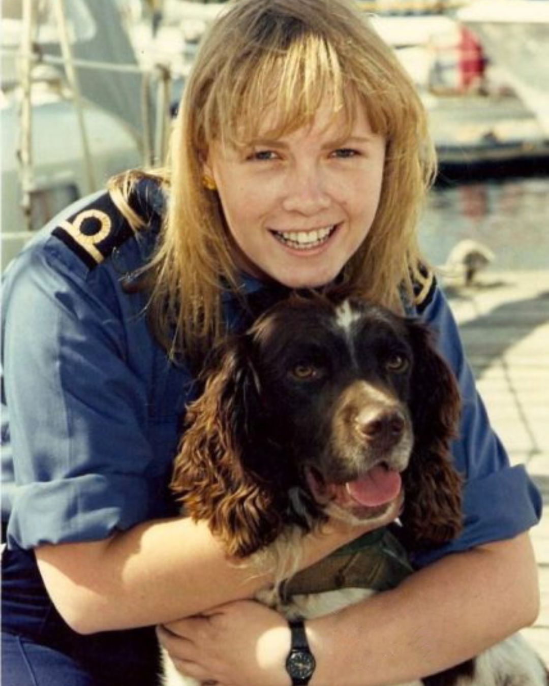 customs officer hugging drug detector dog spaniel