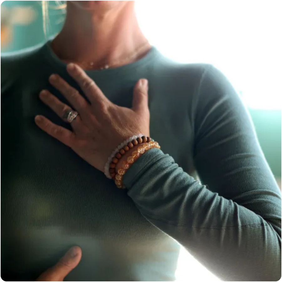 Close-up portrait of meditation teacher Joclyn Kilpatrick with her hand over her heart, representing mindfulness, compassion, and inner connection.
