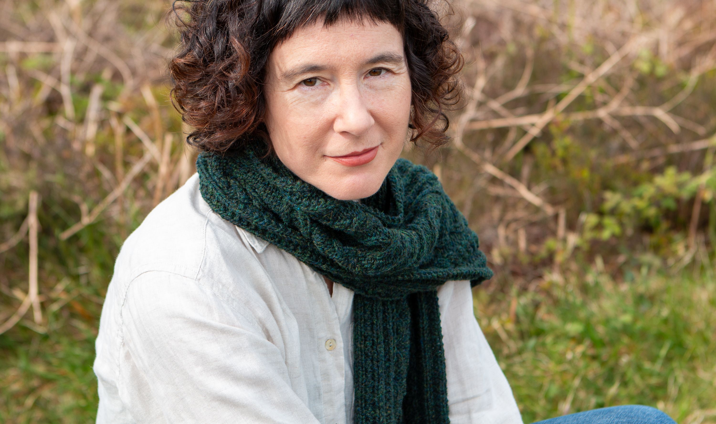 Carol Feller wearing a dark green cabled scarf around her neck.
