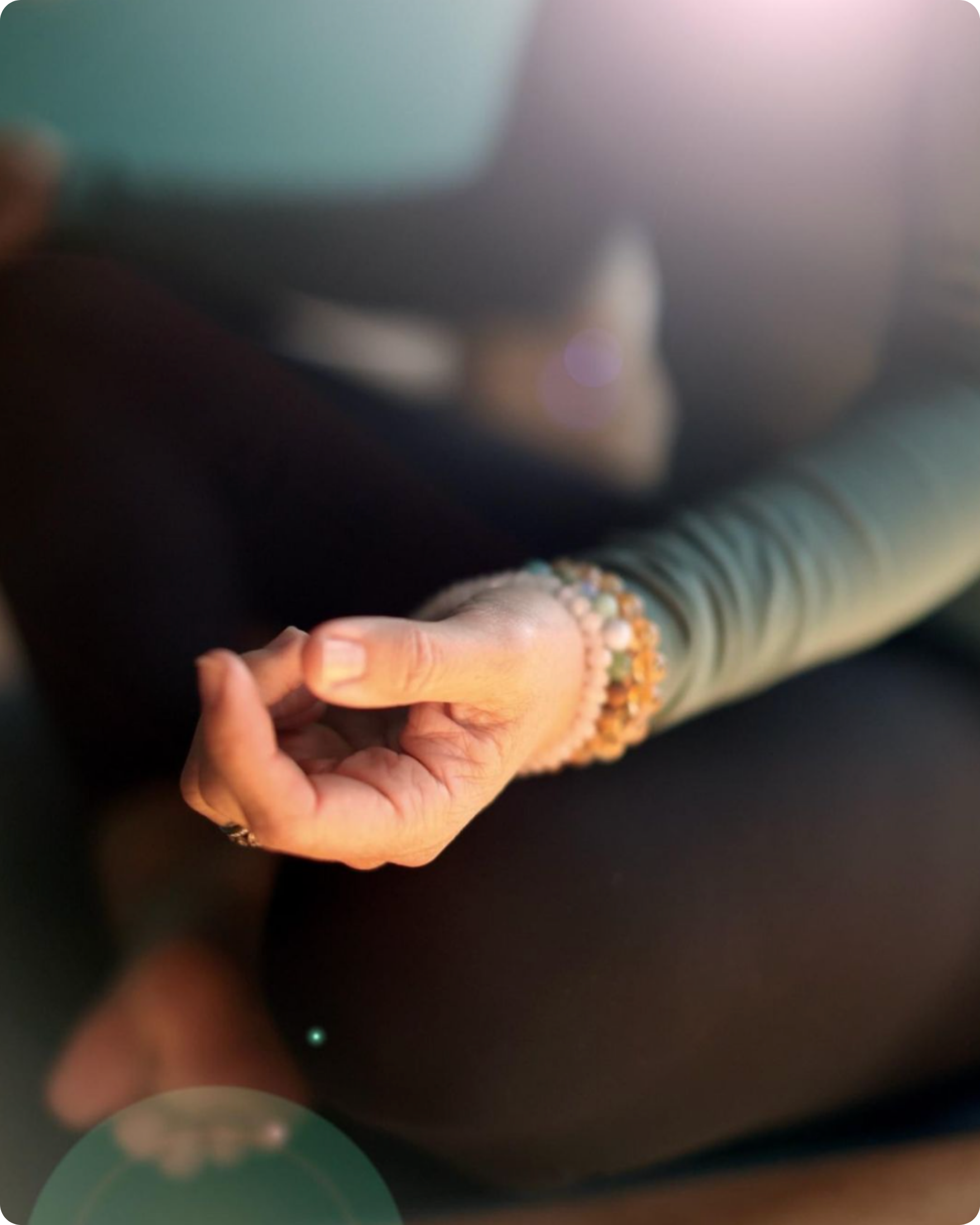 Close-up of a relaxed hand resting during meditation with warm natural light.