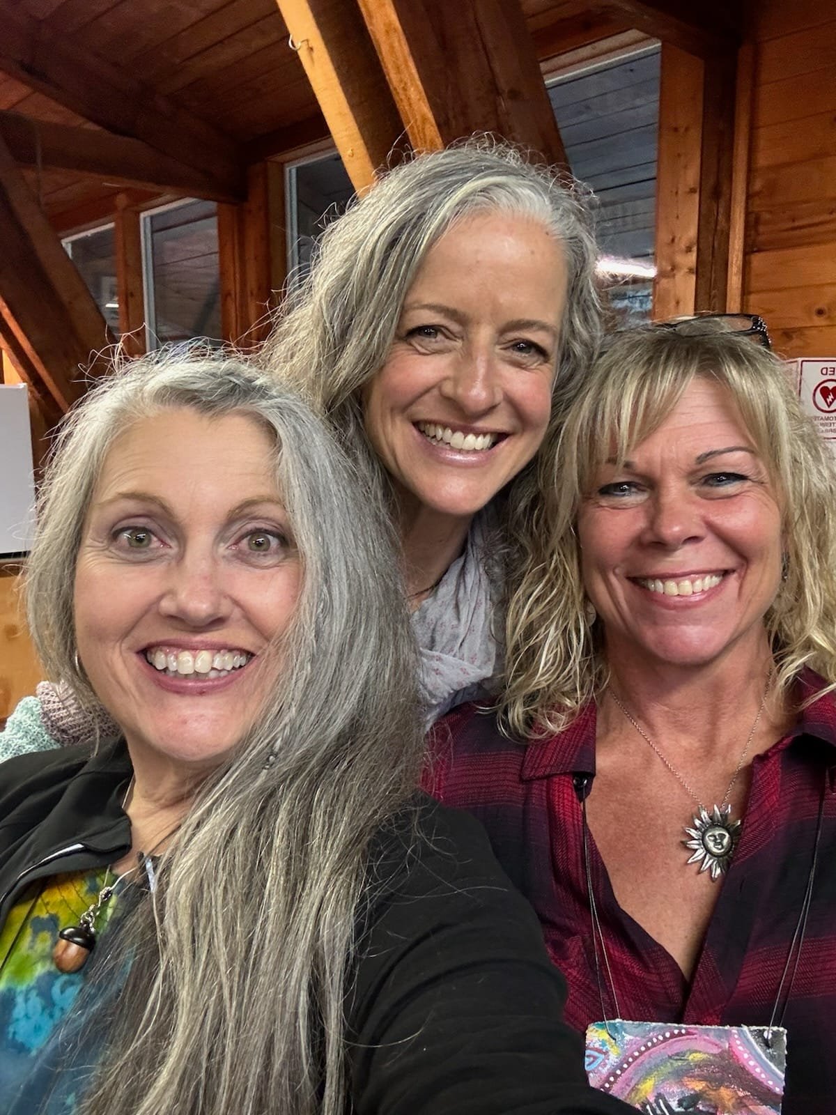 Three women smiling together during the annual Joseph retreat.