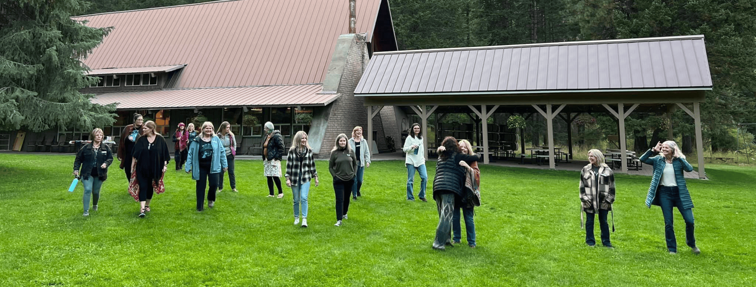 Women gathering outdoors at the Joseph retreat surrounded by mountains and forest.