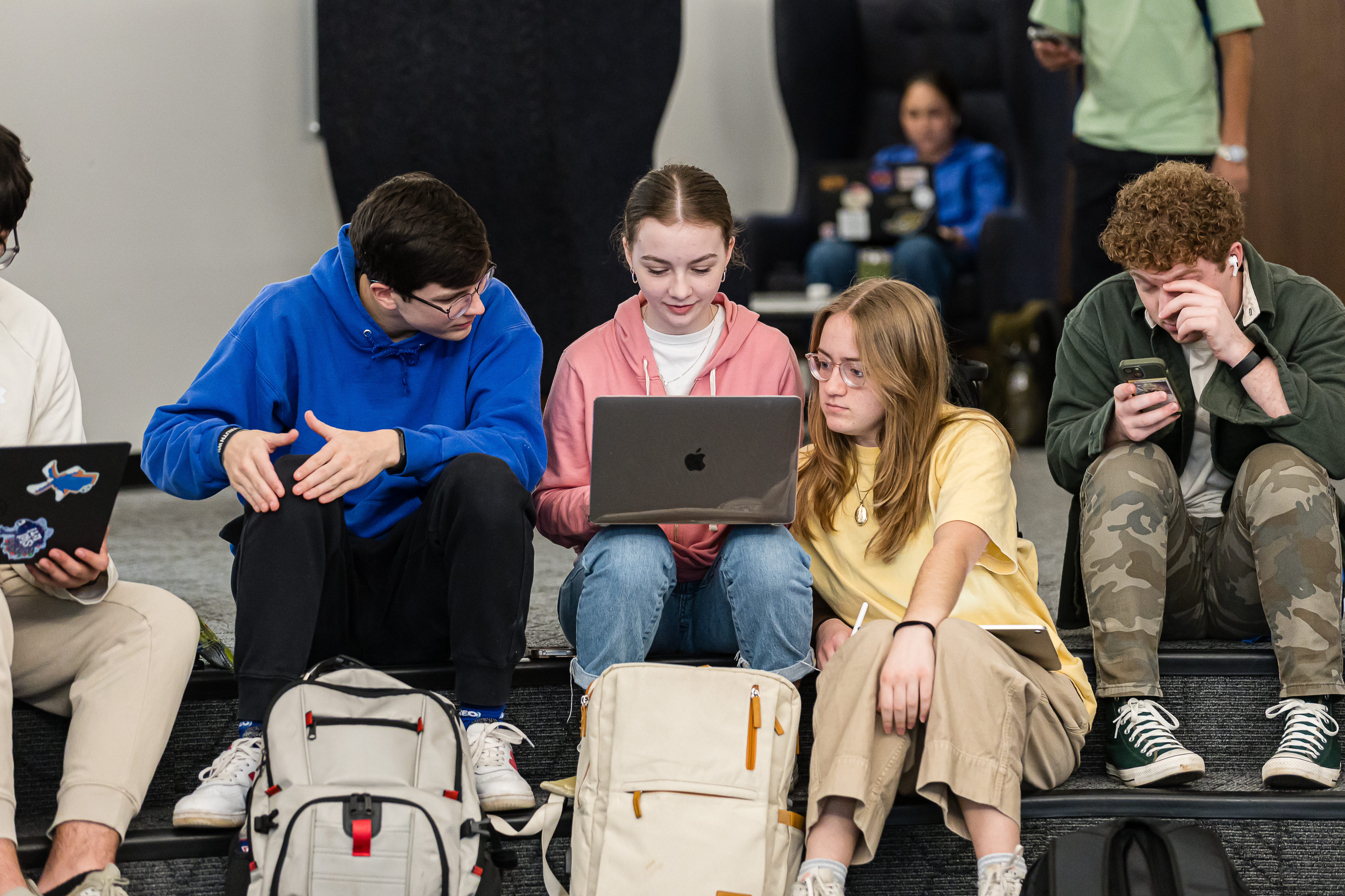 Members of the ORU community collaborating around a laptop